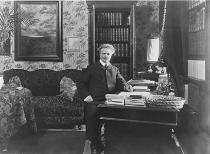 August Strindberg sitter vid sitt skrivbord.
