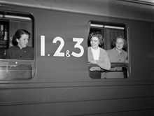 Centralstationen. Tre ungdomar tittar ut genom fönster på en sovvagn