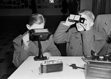 Birger Jarlsgatan 18. Två pojkar tittar i stereoskop, under fotoutställning i Ostermans marmorhallar