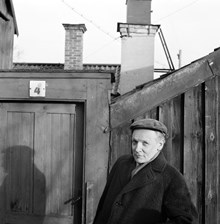 Författaren Per Anders Fogelström framför porten till Kvastmakarbacken 4. Halvbild