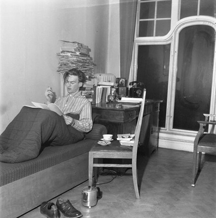 Ola Svensson sitter i en sovsäck på en dagbädd och läser. En stol intill med bland annat en kaffekopp.