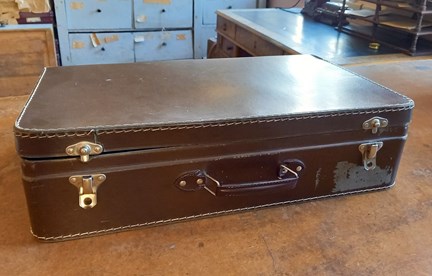 En brun resväska i äldre modell, läder.