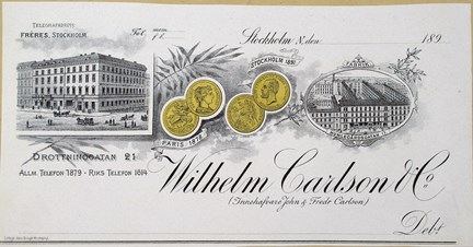 Fakturahuvud i svart och guld med bild på affärslokal, medaljer samt text.