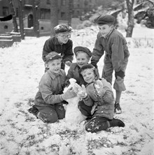 Fem pojkar gör en snögubbe i snön