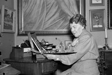 Konstnärinnan Jenny Nyström vid sitt arbetsbord i sitt hem