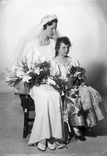 Porträtt av Elsa Göransson, 22 år, född Kastrup, iklädd bröllopsklänning, tillsammans med brudnäbben Birgitta Kastrup, 6 år, bruden syster