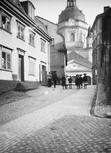 Katarina Kyrkobacke söderut mot Katarina kyrka. En grupp barn står på Katarina Kyrkobacke vid Lilla Fiskaregränd (nuv. Roddargatan)