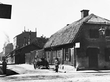 Åsögatan västerut från Södermannagatan. Ett hästfordon står vid Åsögatan 43. Huset revs 1903. Nuv. Åsögatan 139