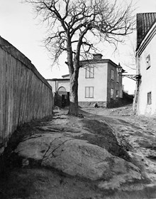 Kvarnbacksgränd norrut från Brännkyrkagatan 112 till Brännkyrkagatan 114. Gården hette Maria barnhärbärge ""Sparvhemmet"" som revs 1907