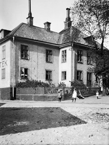 Några barn leker utanför Apoteket Wasen vid Lilla Allmänna Gränd 9. Dåvarande kv. Trädgården, senare kv. Masten