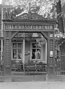 Djurgårdsslätten 78, Lilla Hasselbacken. Café med trädgårdsmöbler och portal mot gatan