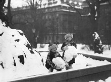 Barn som leker med snö vid Molins fontän i Kungsträdgården
