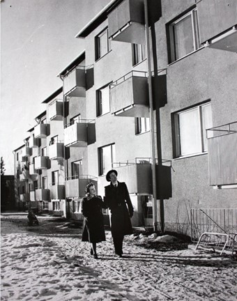 Svartvitt fotografi på par vid hus i Kärrtorp