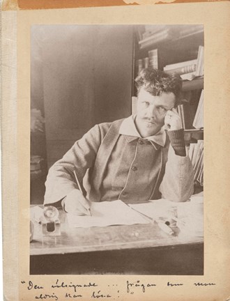 Svartvitt fotografi av Strindberg vid skrivbordet, med huvudet vilande mot handen, iklädd stickade handledsvärmare
