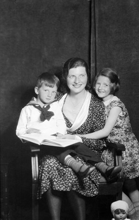 Svart/vitt fotografi av sittande kvinna med två barn