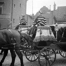 Kunglig vagn med två kuskar klädda i uniformer