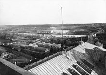 Utsikt från Åhlén & Holms tornbyggnad åt SO över växthus i Stadens trädgård, Hammarbyleden och General Motors fabriksanläggning