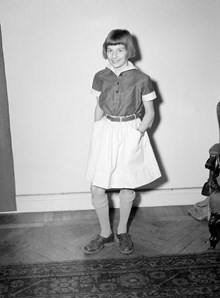 En flicka visar upp barnkläder från barnkonfektion Jolanta
