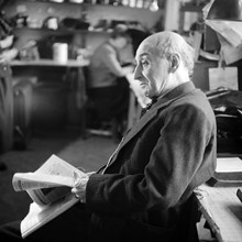 Fotograf Julius Grape läser tidning i sin ateljé