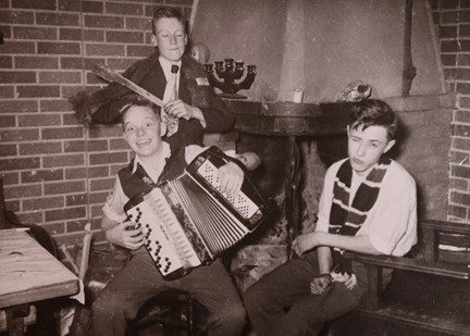 Svartvitt fotografi på tre pojkar med musikinstrument