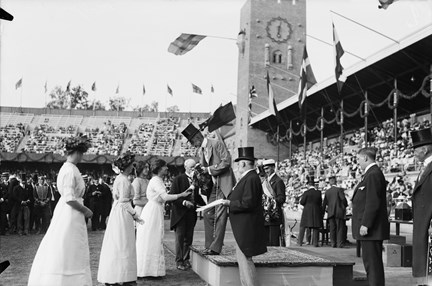 Olympiska spelen i Stockholm 1912. Det segrande engelska laget i damernas lagkappsimning 400 meter erhåller pris av Kung Gustaf V.