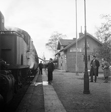 Hässelby Villastads tågstation och stationshus. En stins står på perrongen