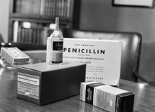 En ampull penicillin samt förpackningar med engelsk text uppställda på ett skrivbord. Penicillin prövades sedan ett par månader vid svenska sjukhus
