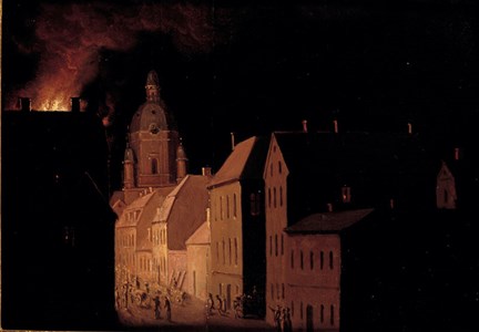 En brand på Högbergsgatan på Söder har brutit ut. Tornet på Katarina kyrka och husfasader är upplysta i kontrast mot mörkret.