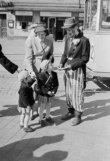 Tegelbacken. Jur. studerande Lars Nycander, utklädd till clown, säljer nyckelhäfte med ""nycklar"" till Stockholm. Nyckelhäftet innehåller rabattkuponger till evenemang vid Stockholms 700-års jubileum